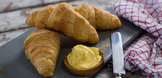 Croissant s máslem, typická francouzská pochoutka.