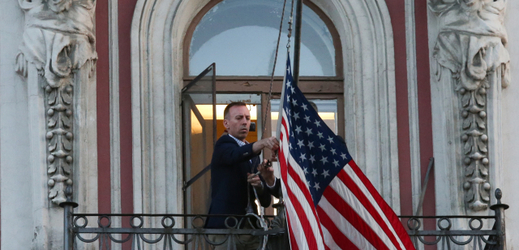 Muž odstraňuje vlajku z ambasády USA v Petrohradě. 
